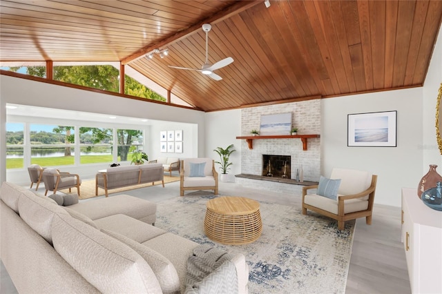 living room featuring a water view, ceiling fan, wooden ceiling, and plenty of natural light