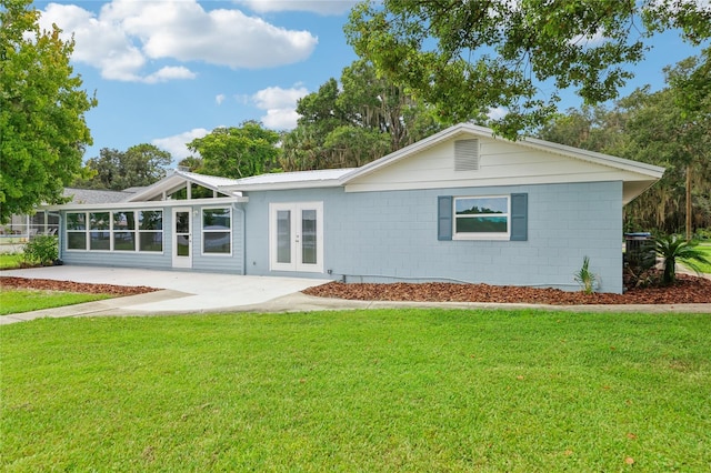 back of property featuring a patio, french doors, and a yard