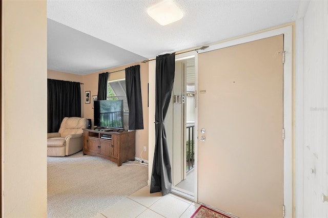 entrance foyer featuring a textured ceiling and light tile patterned floors