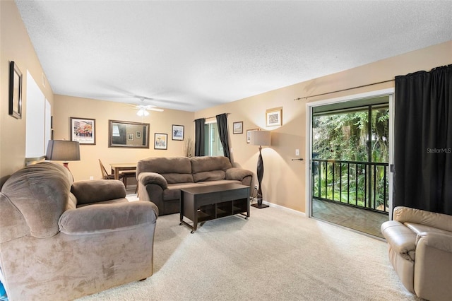 living room featuring light carpet, ceiling fan, and a textured ceiling