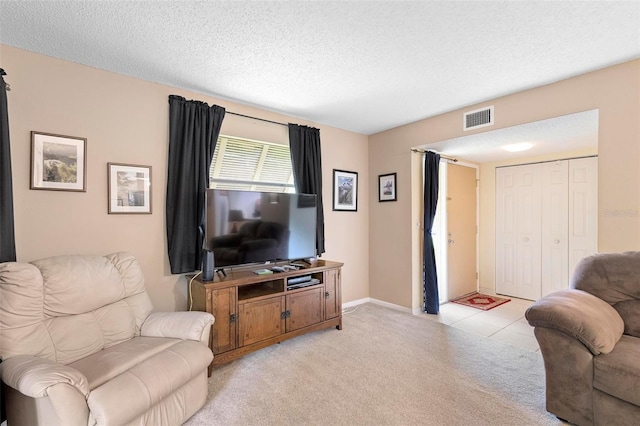 living room with a textured ceiling and light tile patterned floors