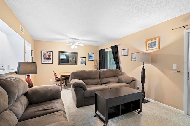 living room featuring a textured ceiling, light colored carpet, and ceiling fan