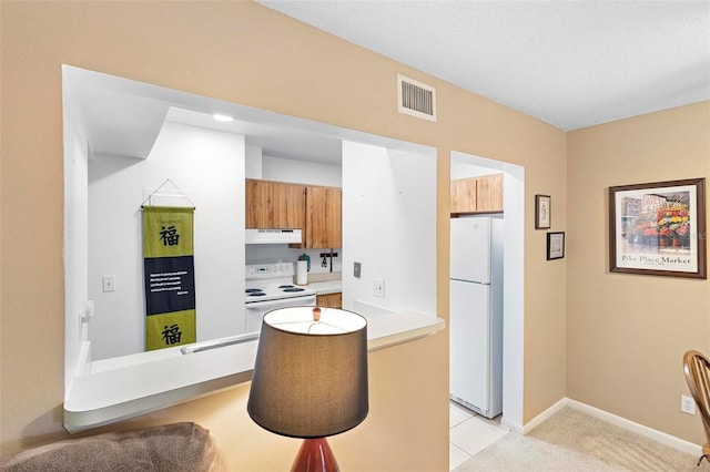 kitchen with white appliances and light tile patterned floors