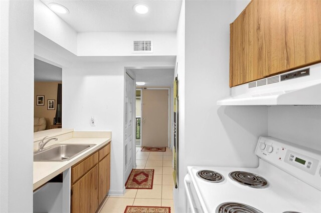 kitchen featuring sink, range, and light tile patterned floors