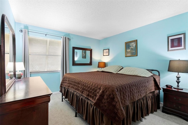 bedroom with a textured ceiling and light colored carpet