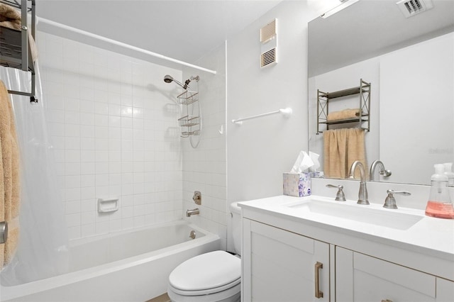 full bathroom featuring vanity, tiled shower / bath combo, and toilet