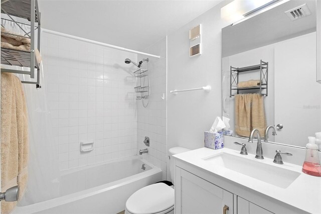 full bathroom with vanity, tiled shower / bath combo, and toilet