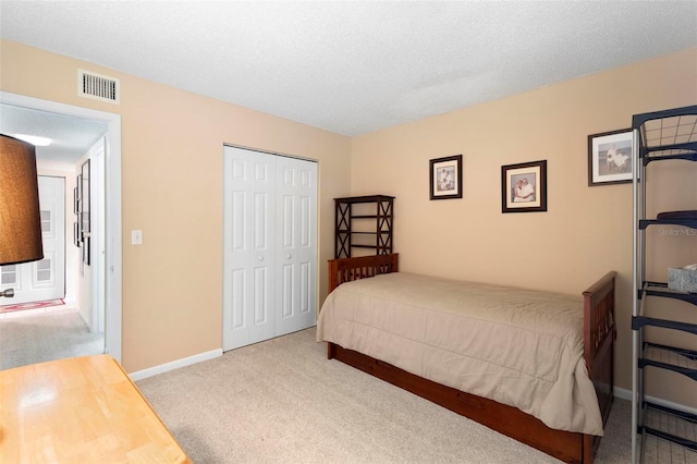 carpeted bedroom featuring a closet and a textured ceiling