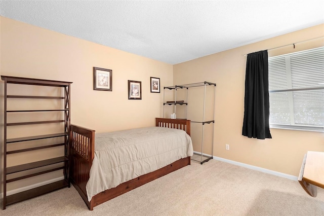 bedroom featuring light colored carpet and a textured ceiling