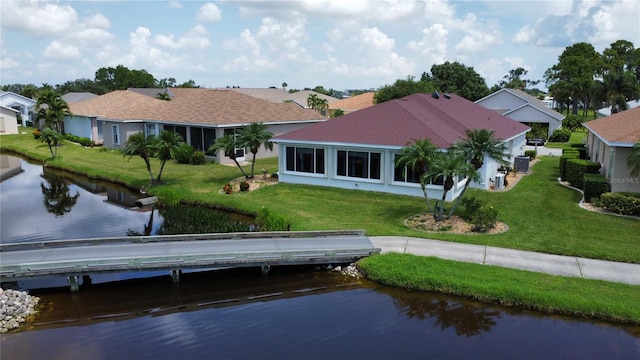 rear view of property featuring a water view and a yard