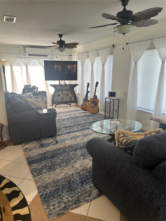 tiled living room featuring a textured ceiling, a wall mounted AC, and ceiling fan