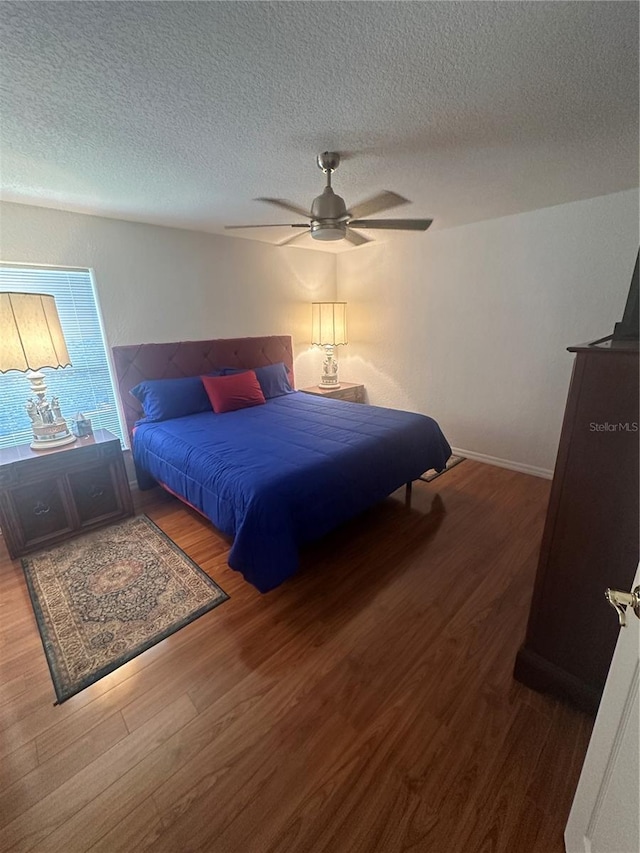 bedroom with ceiling fan, wood-type flooring, and a textured ceiling