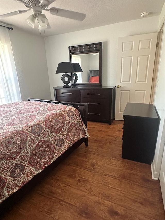 bedroom featuring multiple windows, ceiling fan, and dark hardwood / wood-style flooring