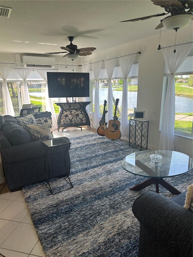 living room with tile patterned floors, ceiling fan, a textured ceiling, and a wall mounted AC