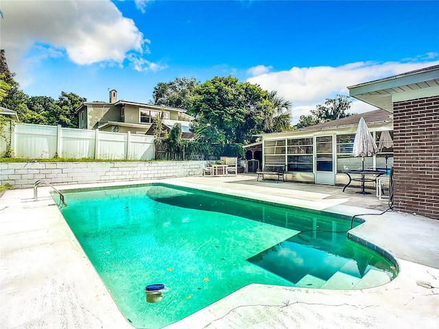 view of pool featuring a patio area and a sunroom