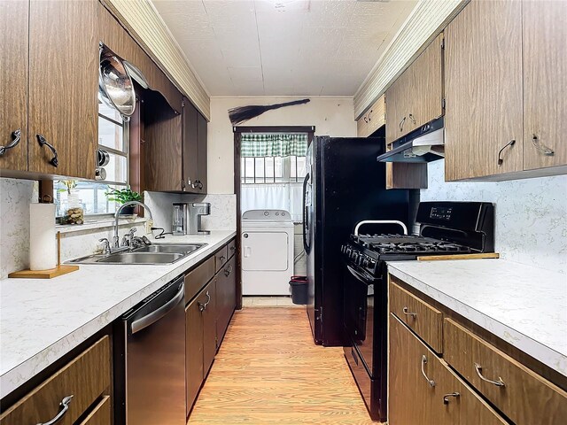 kitchen featuring sink, light hardwood / wood-style flooring, black gas stove, washer / clothes dryer, and stainless steel dishwasher