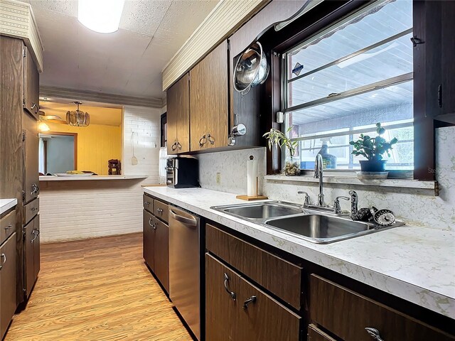 kitchen featuring sink, crown molding, dishwasher, hanging light fixtures, and light wood-type flooring