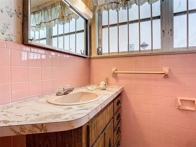 bathroom with vanity and tile walls