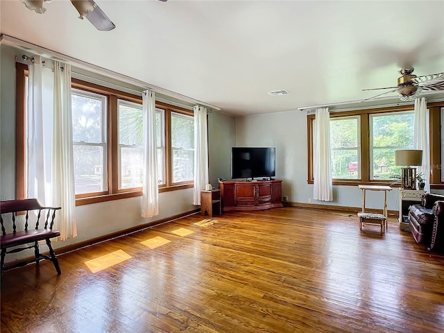 living room featuring wood-type flooring and ceiling fan