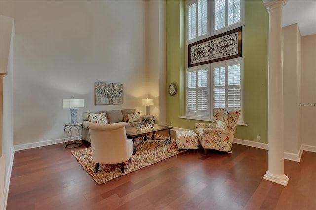 living room featuring dark hardwood / wood-style flooring and decorative columns