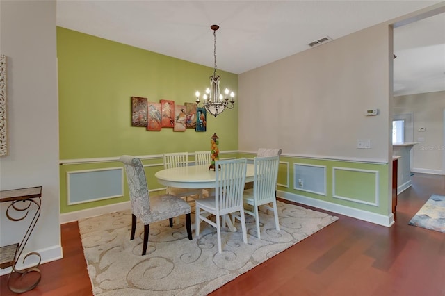 dining area with a chandelier and dark hardwood / wood-style flooring