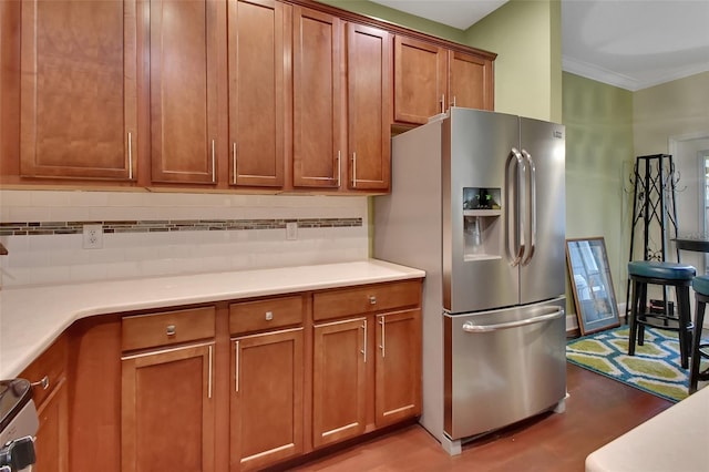 kitchen with backsplash, crown molding, light hardwood / wood-style flooring, and stainless steel fridge