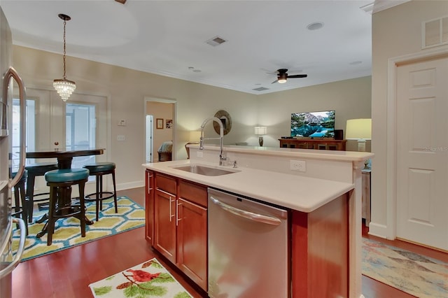 kitchen with ceiling fan with notable chandelier, stainless steel dishwasher, sink, hardwood / wood-style flooring, and a center island with sink