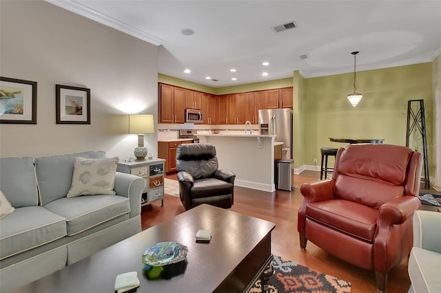 living room with sink, wood-type flooring, and crown molding