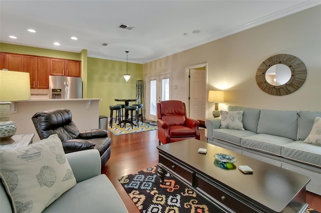 living room with wood-type flooring and ornamental molding