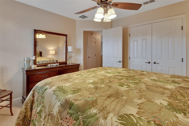 bedroom with a closet, ceiling fan, and light colored carpet