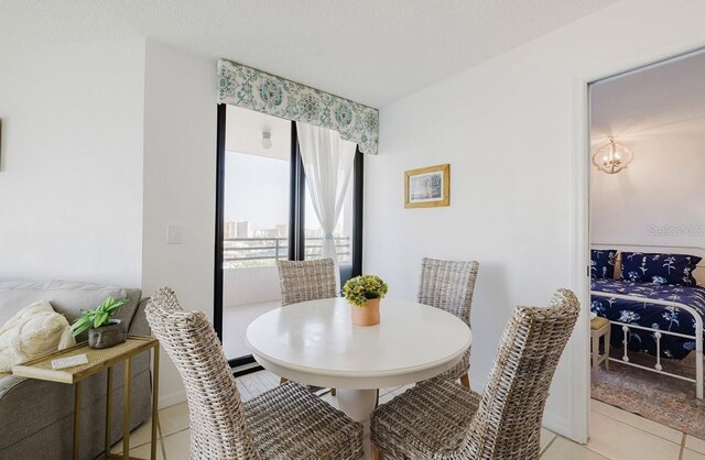 tiled dining room featuring a chandelier