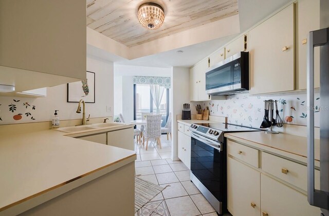 kitchen with wooden ceiling, stainless steel appliances, a tray ceiling, light tile patterned floors, and sink