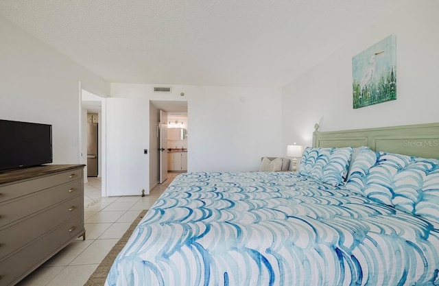 bedroom with light tile patterned floors and a textured ceiling