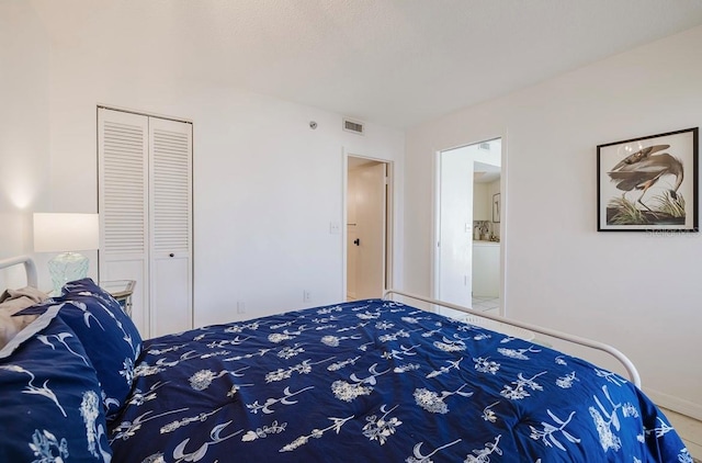 bedroom with tile patterned floors and a closet