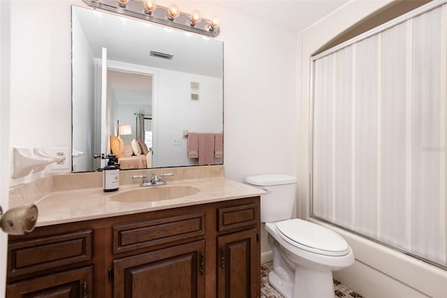 full bathroom featuring vanity, bath / shower combo with glass door, and toilet