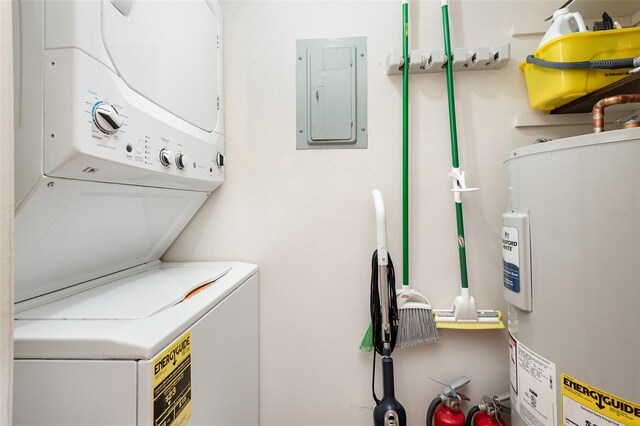 laundry area with electric water heater, stacked washing maching and dryer, and electric panel