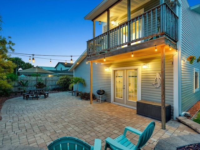 view of patio / terrace featuring a balcony, fence, and french doors