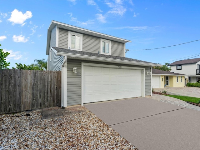 view of front facade featuring driveway and fence