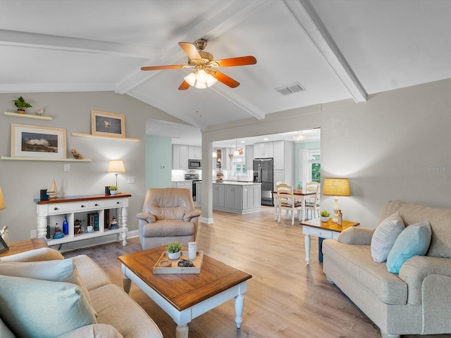 living room featuring lofted ceiling with beams, ceiling fan, visible vents, baseboards, and light wood-type flooring