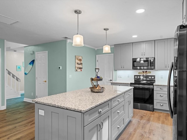 kitchen featuring black appliances, a kitchen island, gray cabinets, and light wood-style floors