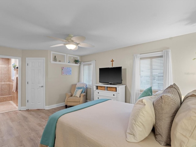 bedroom with light wood-style flooring, baseboards, a ceiling fan, and ensuite bathroom