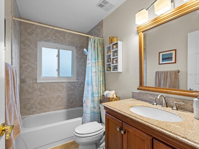 bathroom with visible vents, vanity, toilet, and shower / bath combo with shower curtain