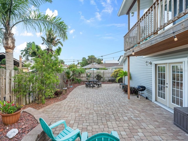 view of patio featuring an outdoor fire pit, french doors, a fenced backyard, and a grill