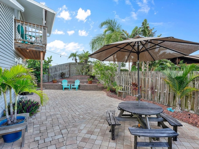 view of patio / terrace featuring a fenced backyard and a balcony