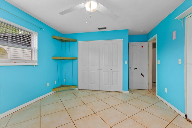 unfurnished bedroom featuring ceiling fan, a closet, and light tile patterned floors