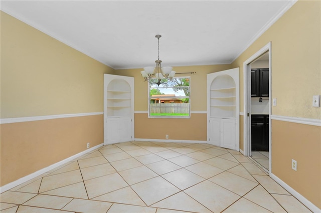 tiled empty room featuring built in features and a chandelier