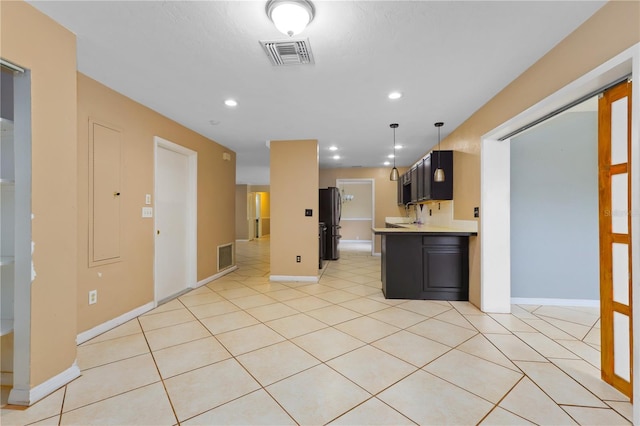 kitchen featuring light tile patterned flooring, kitchen peninsula, and stainless steel fridge