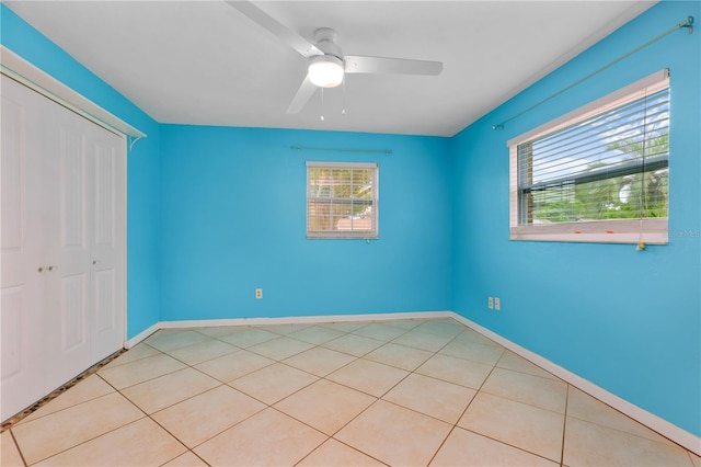 unfurnished bedroom featuring light tile patterned floors, a closet, and ceiling fan