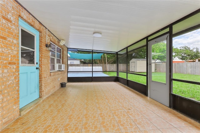 unfurnished sunroom featuring cooling unit and a wealth of natural light