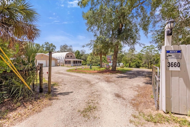 view of road with a gate, a gated entry, and dirt driveway